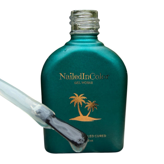 Teal bottle of Nailed In Color gel with a nail polish brush showing topcoat on a white background