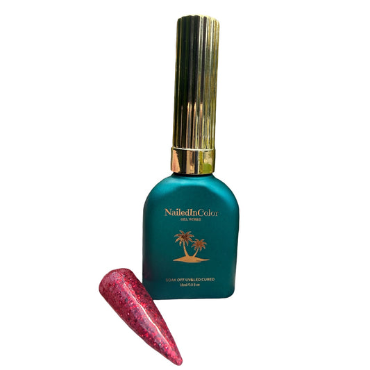 Teal nail polish bottle with gold cap and red glittery nail swatch on a white background