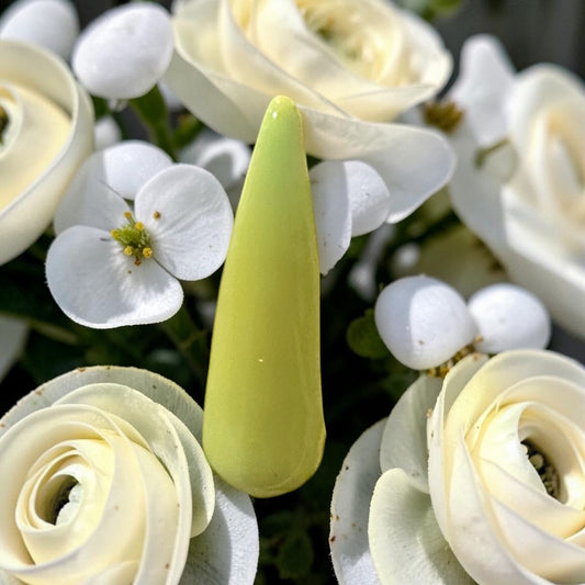 Yellow polished nail tip resting on white florals