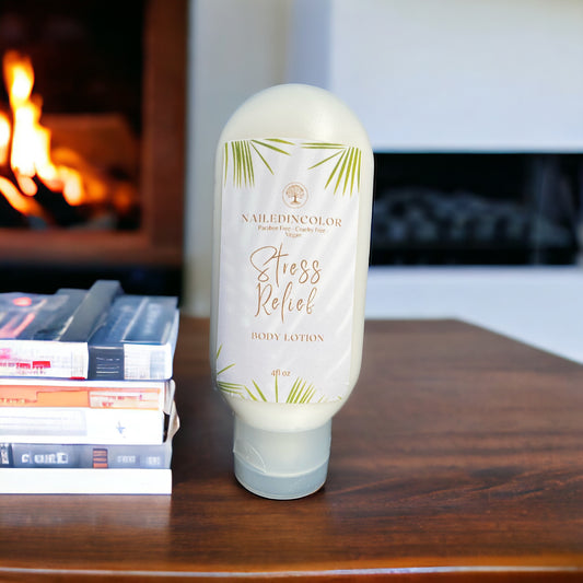A bottle of NailedinColor Stress Relief Body Lotion stands on a wooden table in front of a blurred fireplace and books.
