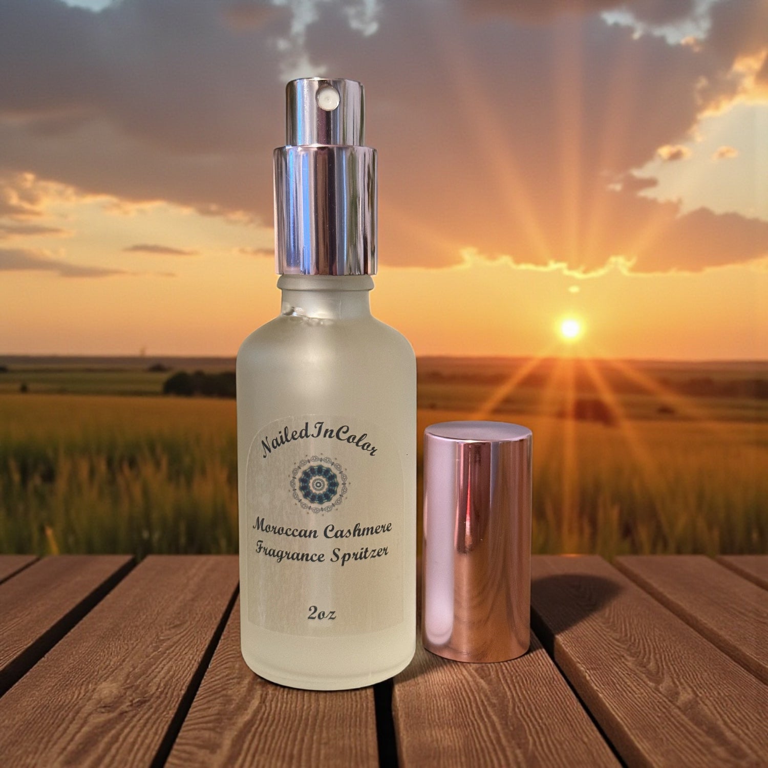 Moroccan Cashmere Fragrance spritzer bottle with a sunset background