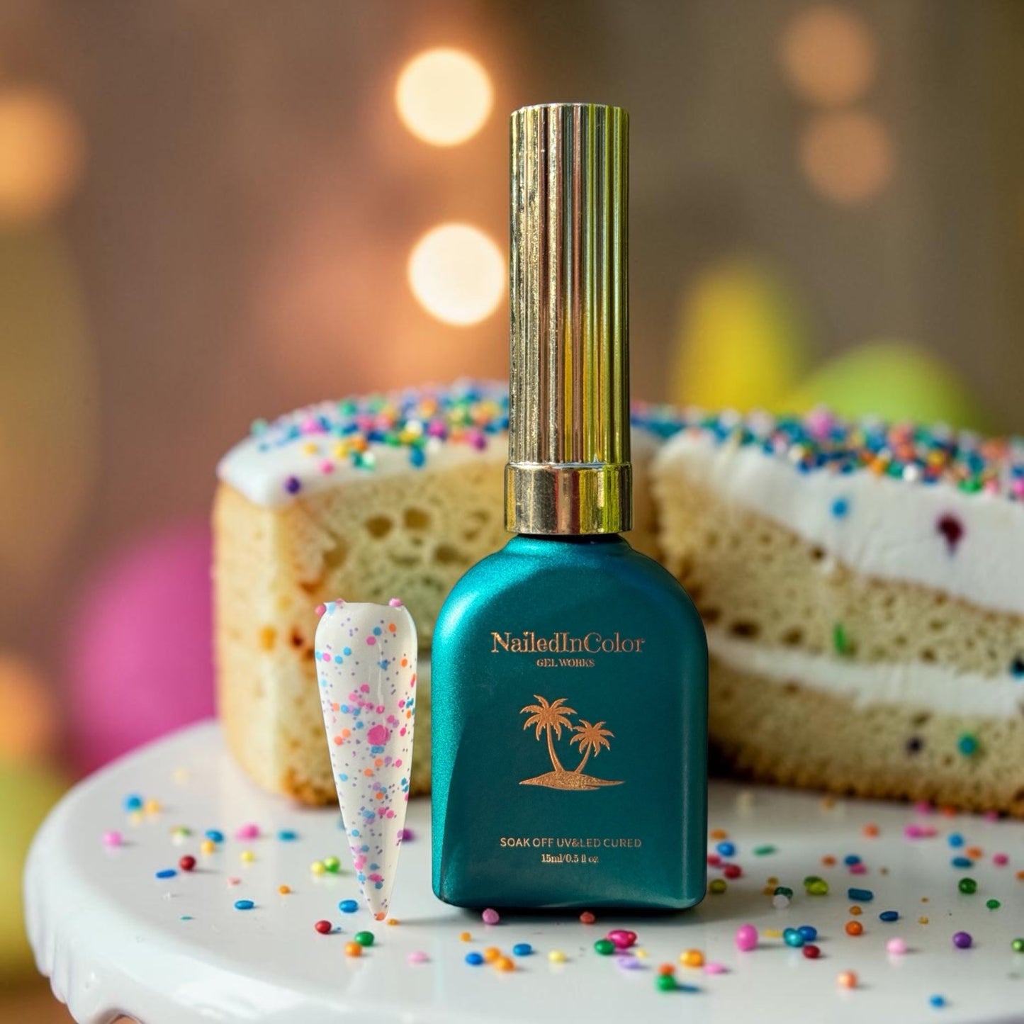 Green gel nail polish bottle with a palm tree design on a cake with colorful sprinkles.
