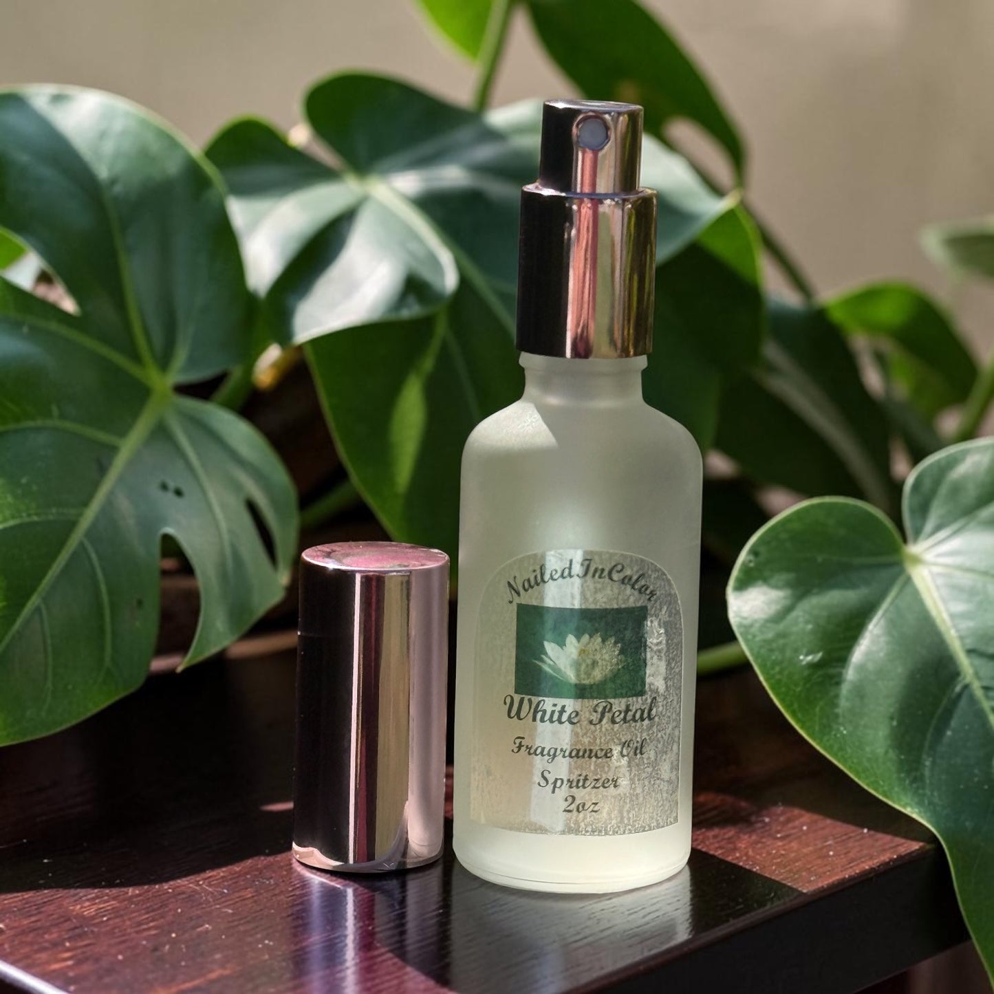 White Petal soft floral body mist bottle on table with plants in background