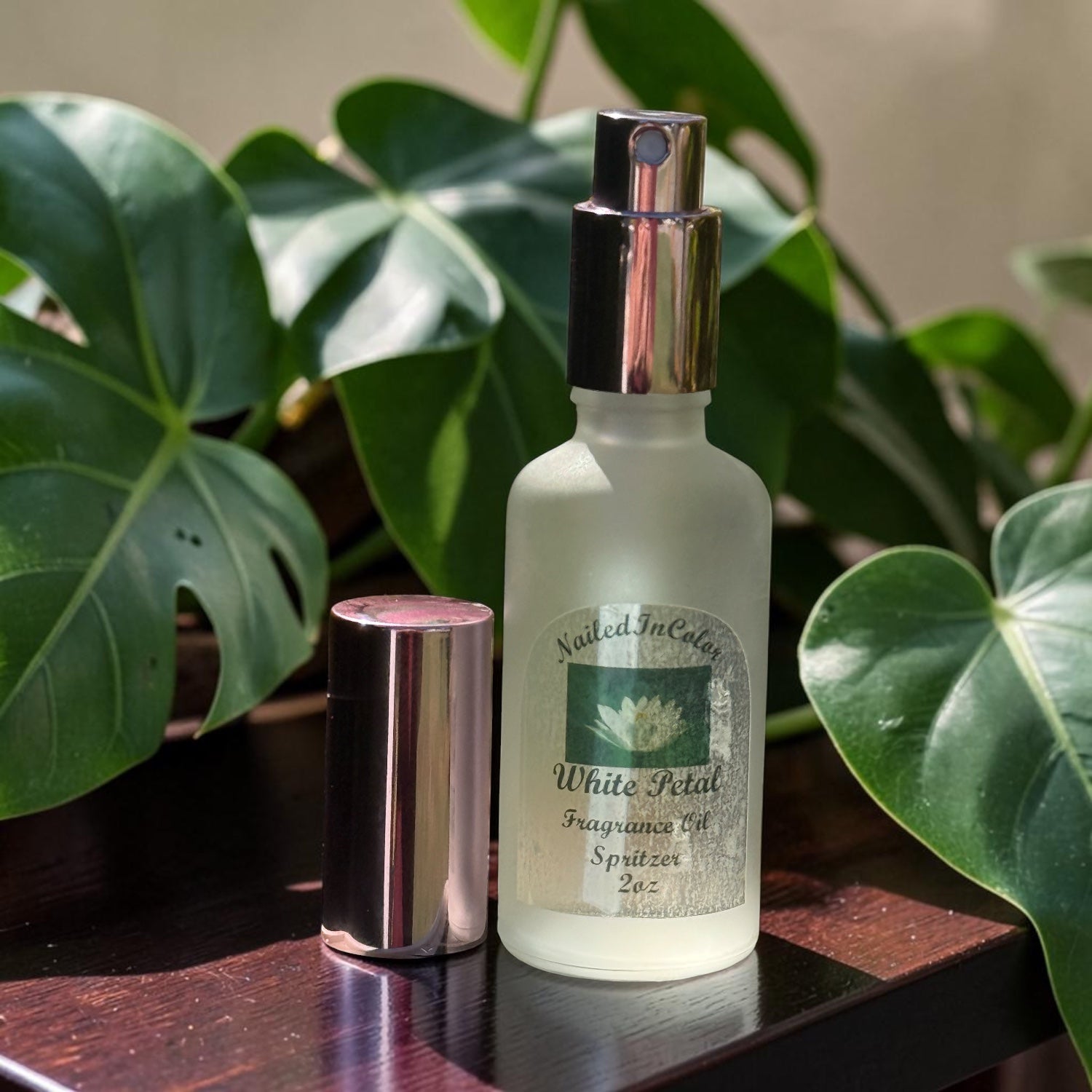 White Petal soft floral body mist bottle on table with plants in background