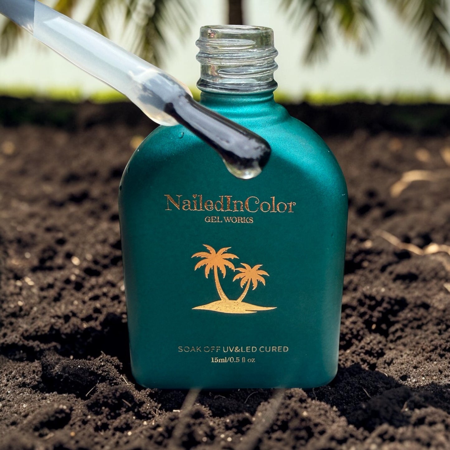 Nailed In Color gel bottle with a nail brush with topcoat on soil with palm tree in background