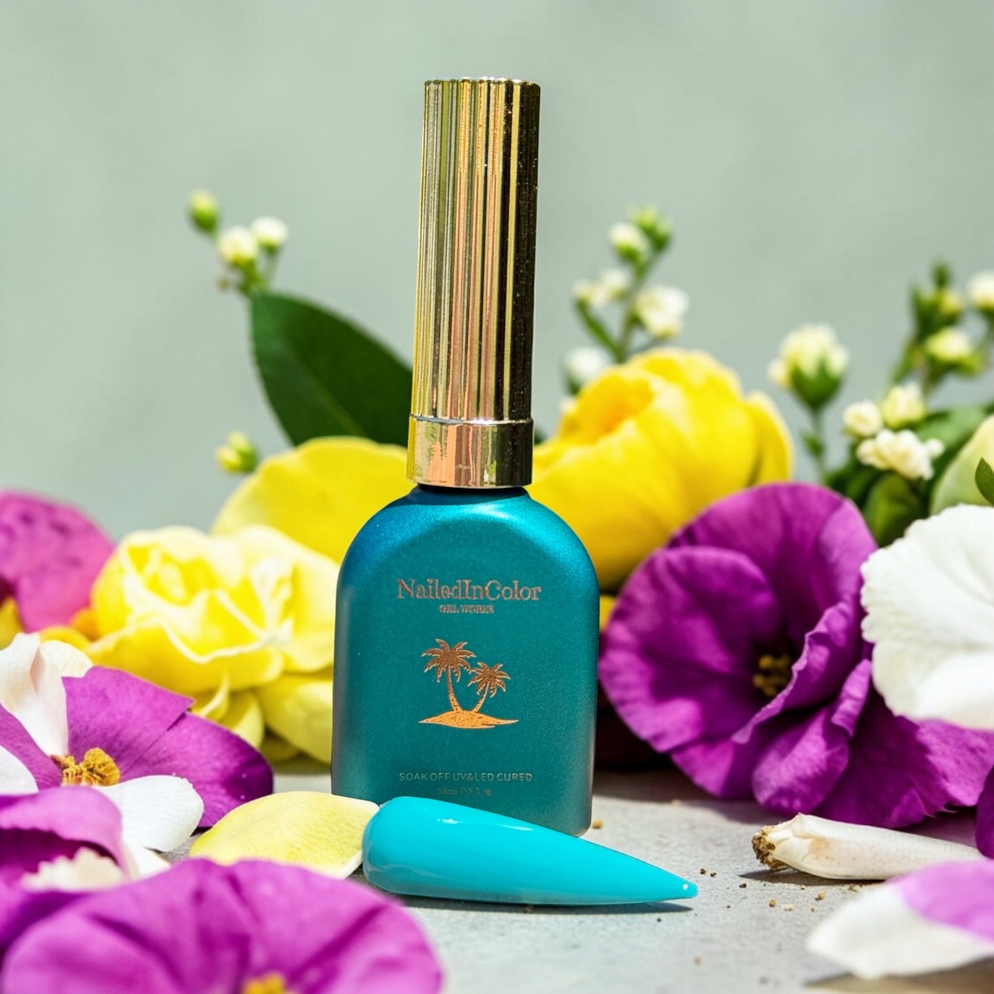 Green gel polish bottle with florals in background and a blue green nail swatch