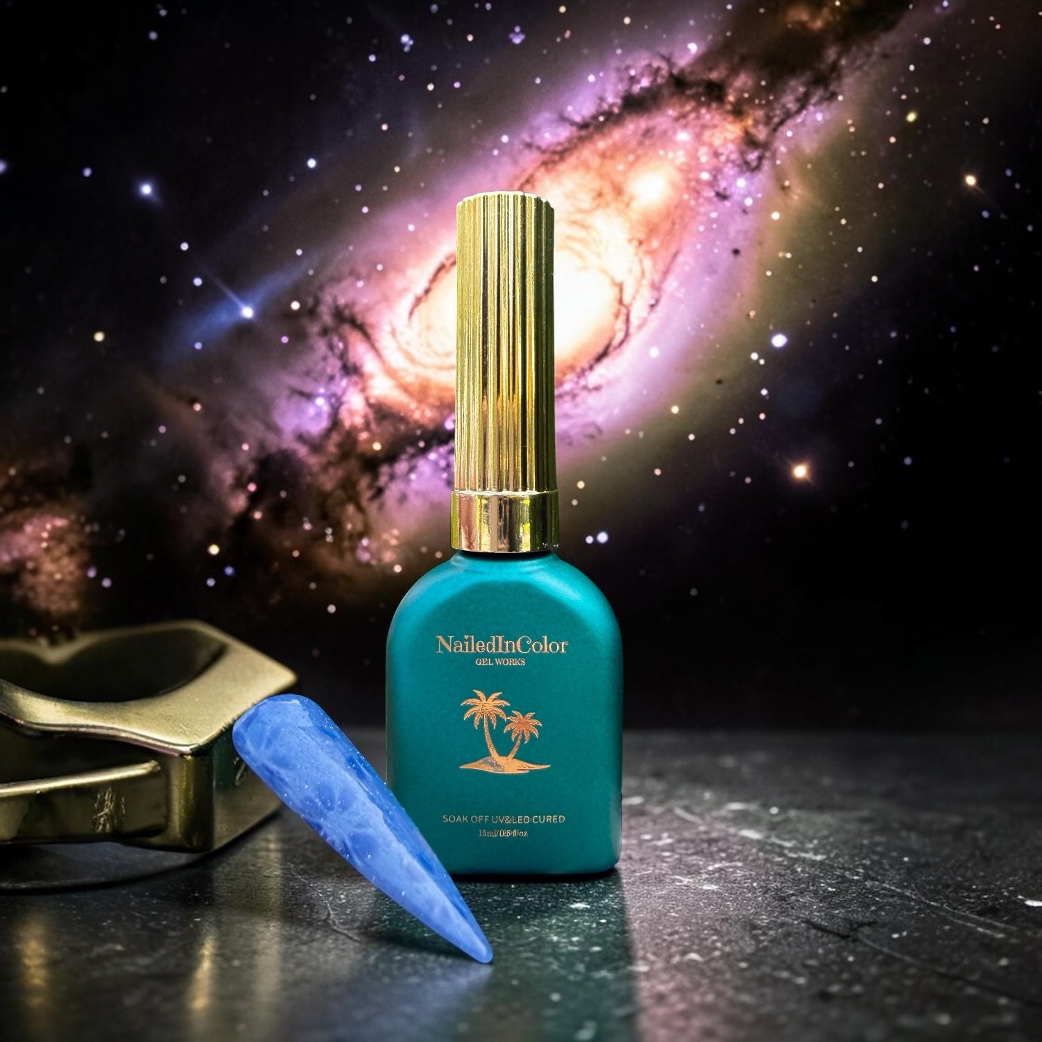Green nail polish bottle with gold cap on a reflective surface against a galaxy background and a nail sample of gel polish cat eye flower designs created by magnet