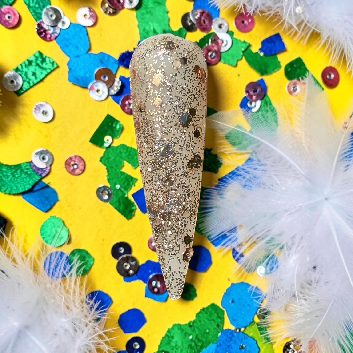 Decorative glitter gold nail swatch with glittery surface on a colorful, festive background