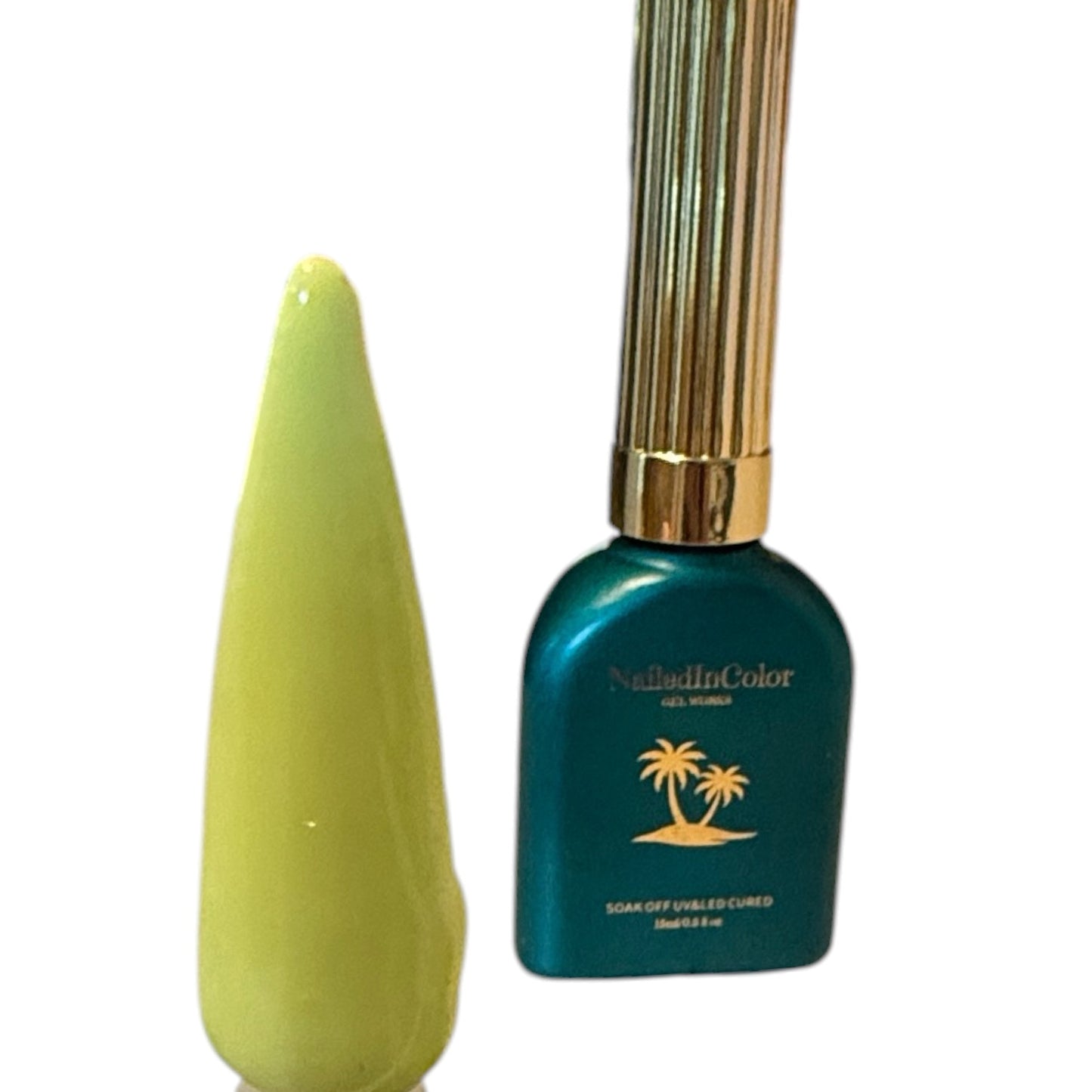 Yellow gel polished nail tip next to a green polish botte with a gold cap and a white background
