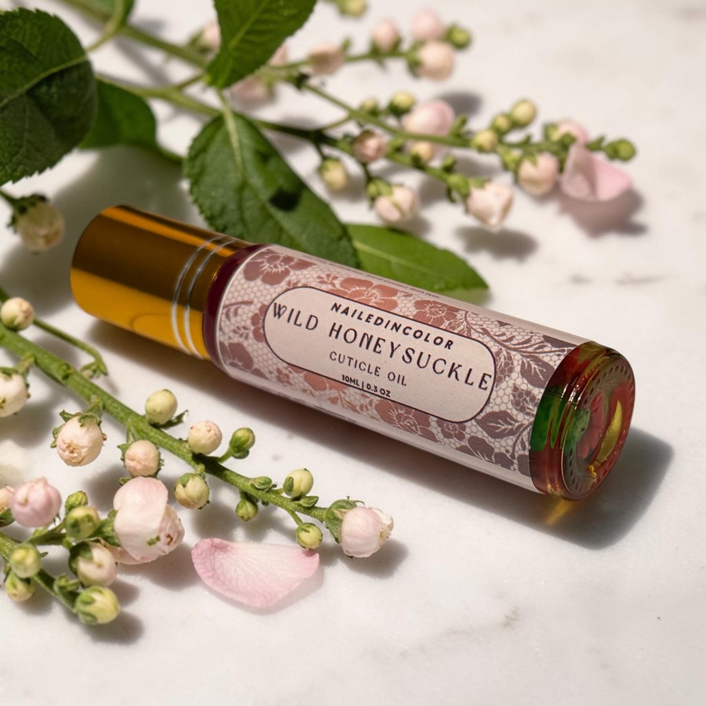wild honeysuckle cuticle oil laying in between small florals