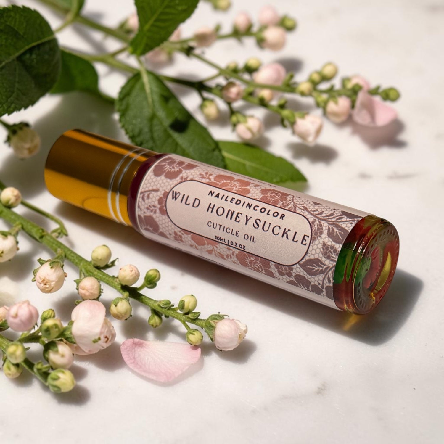 wild honeysuckle cuticle oil laying in between small florals