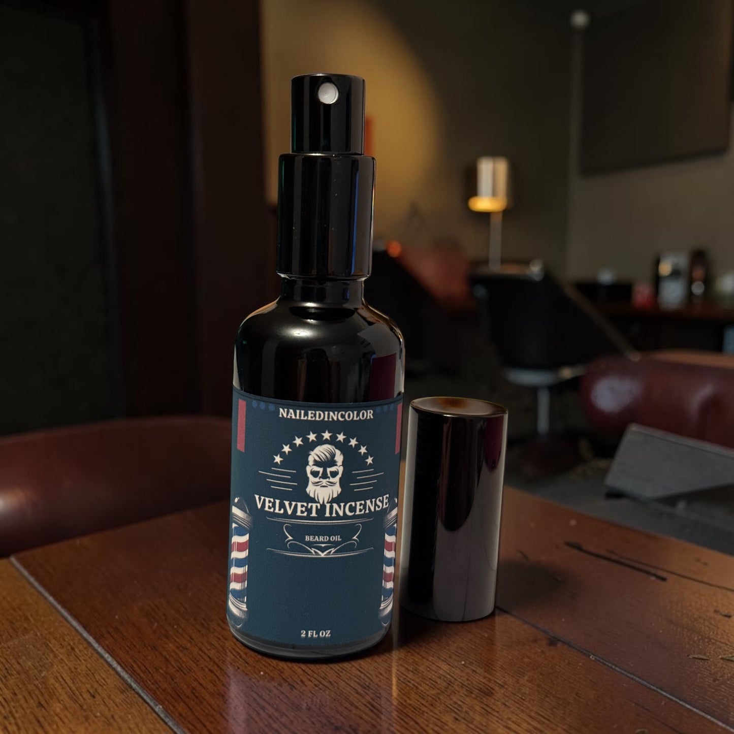 A dark glass spray bottle labeled 'NAILEDINCOLOR VELVET INCENSE' stands on a wooden table, with its cap placed beside it in a dimly lit indoor setting.