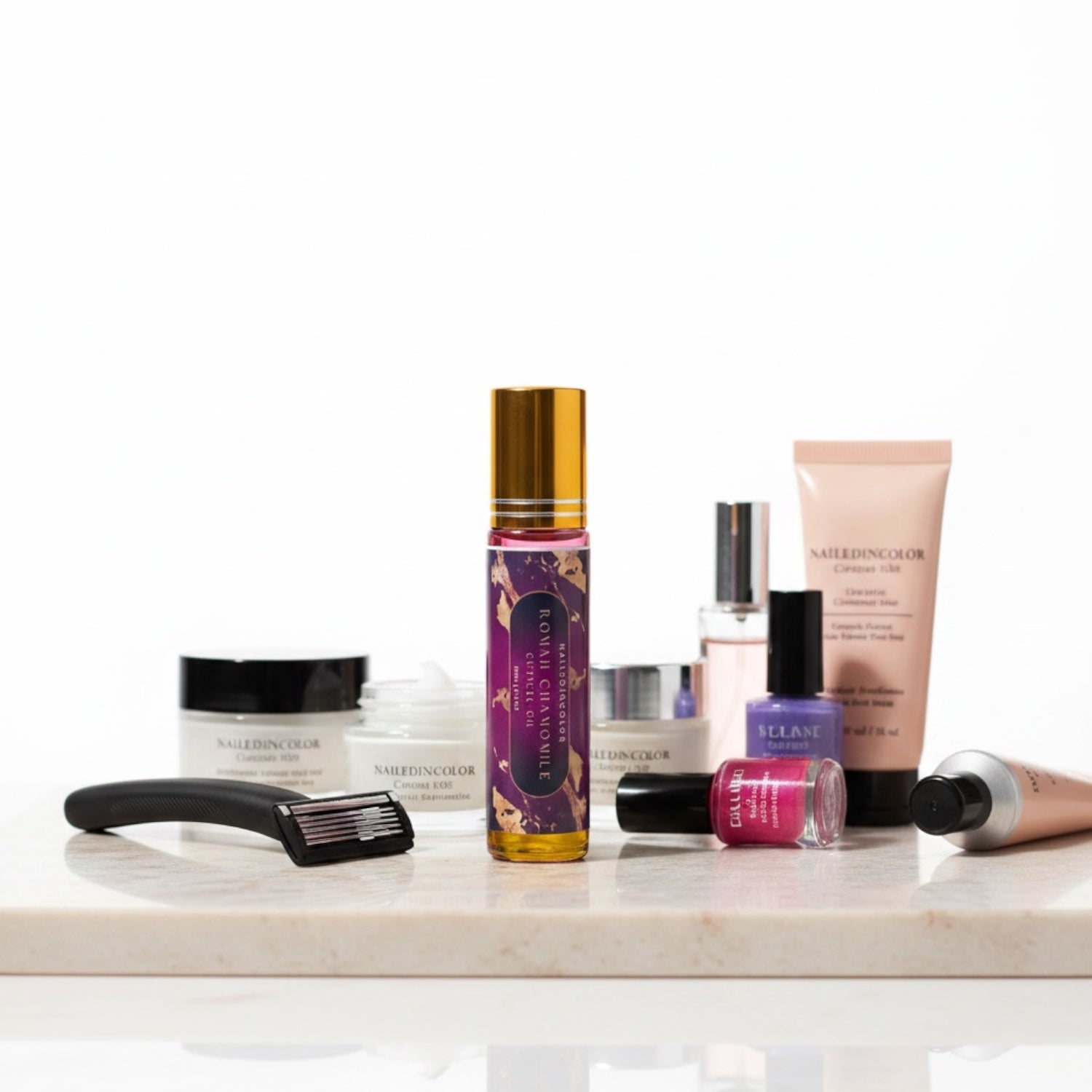 A curated collection of beauty products  arranged on a white marble slab against a white background. The collection includes a roman chamomile cuticle oil, a pink nail polish, a black hair tool, and various cream and gel products in beige, white, and purple packaging.